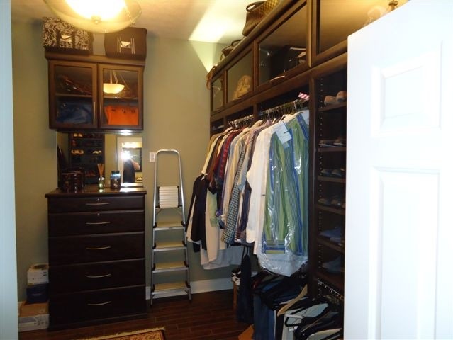 Foto de armario vestidor unisex minimalista grande con armarios tipo vitrina, puertas de armario de madera en tonos medios y suelo de baldosas de cerámica