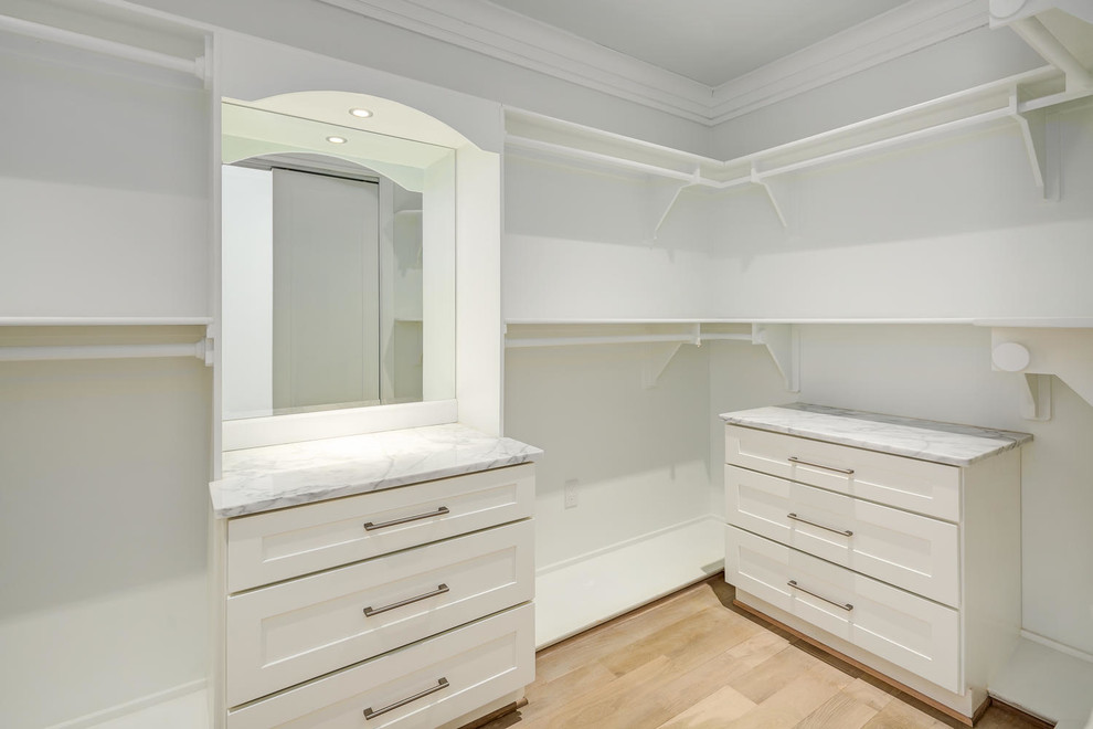 Ejemplo de armario vestidor moderno de tamaño medio con armarios estilo shaker, puertas de armario blancas, suelo de madera clara y suelo beige