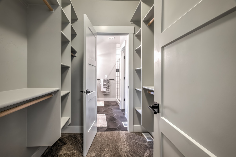 Immagine di una cabina armadio unisex classica di medie dimensioni con pavimento grigio, nessun'anta e moquette