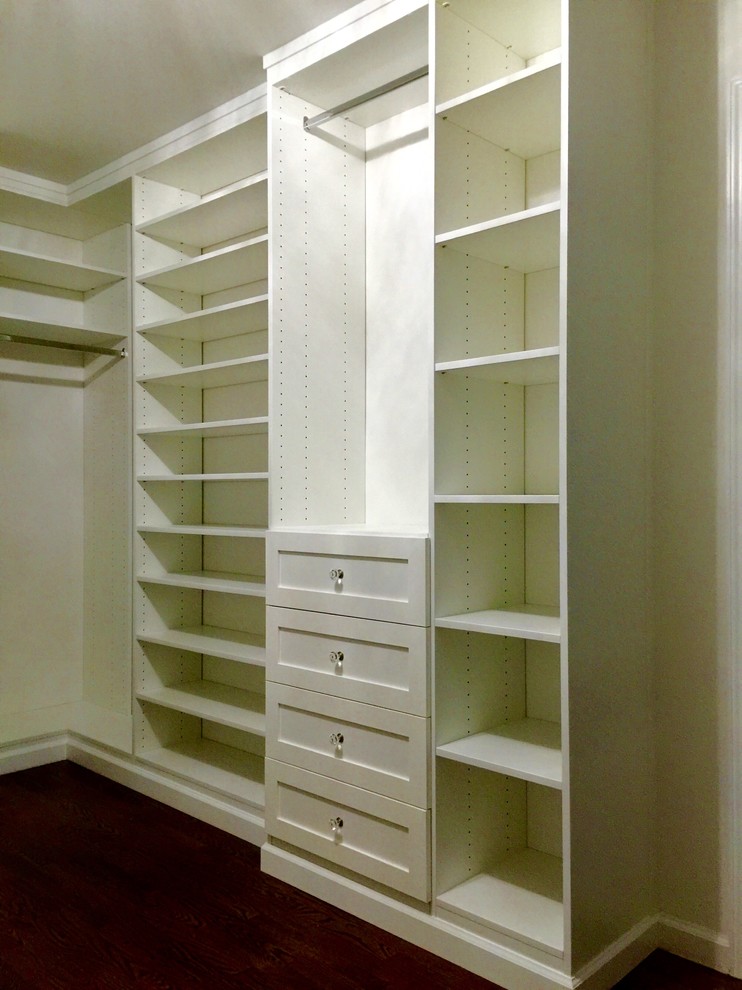 Photo of a large traditional gender neutral walk-in wardrobe in New York with shaker cabinets, white cabinets and dark hardwood flooring.