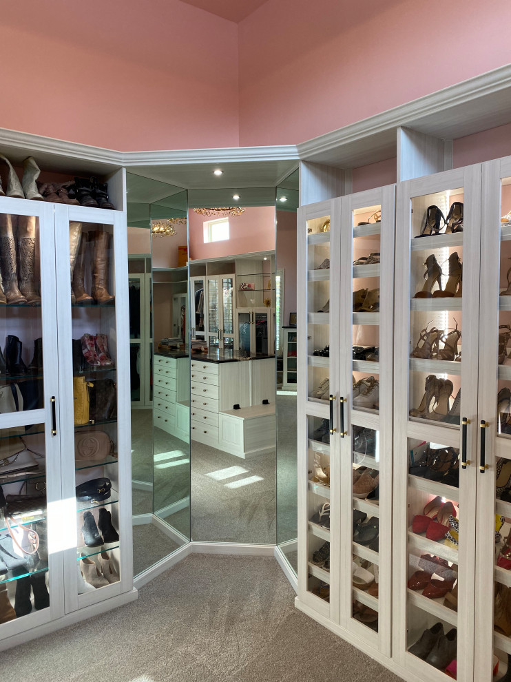 Closet - huge eclectic carpeted closet idea in Charleston with glass-front cabinets and light wood cabinets