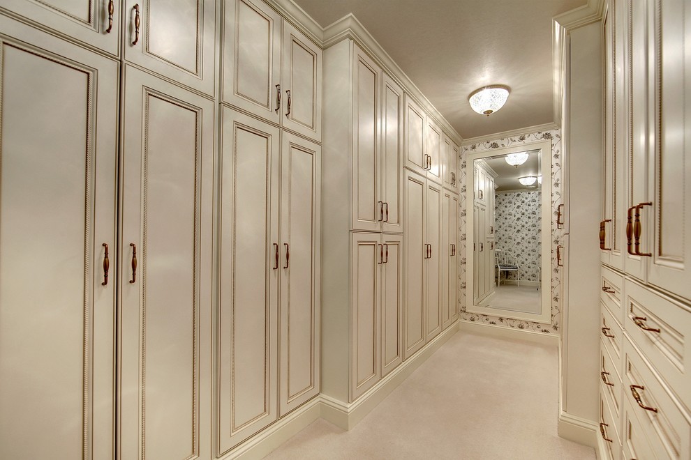 На фото: большая гардеробная комната унисекс в классическом стиле с фасадами с утопленной филенкой, белыми фасадами и ковровым покрытием