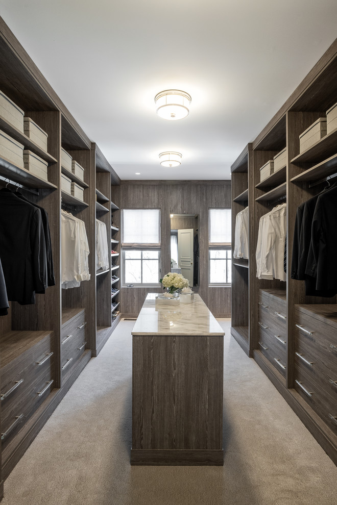 Imagen de armario vestidor unisex actual grande con armarios con paneles lisos, puertas de armario de madera oscura, moqueta y suelo beige