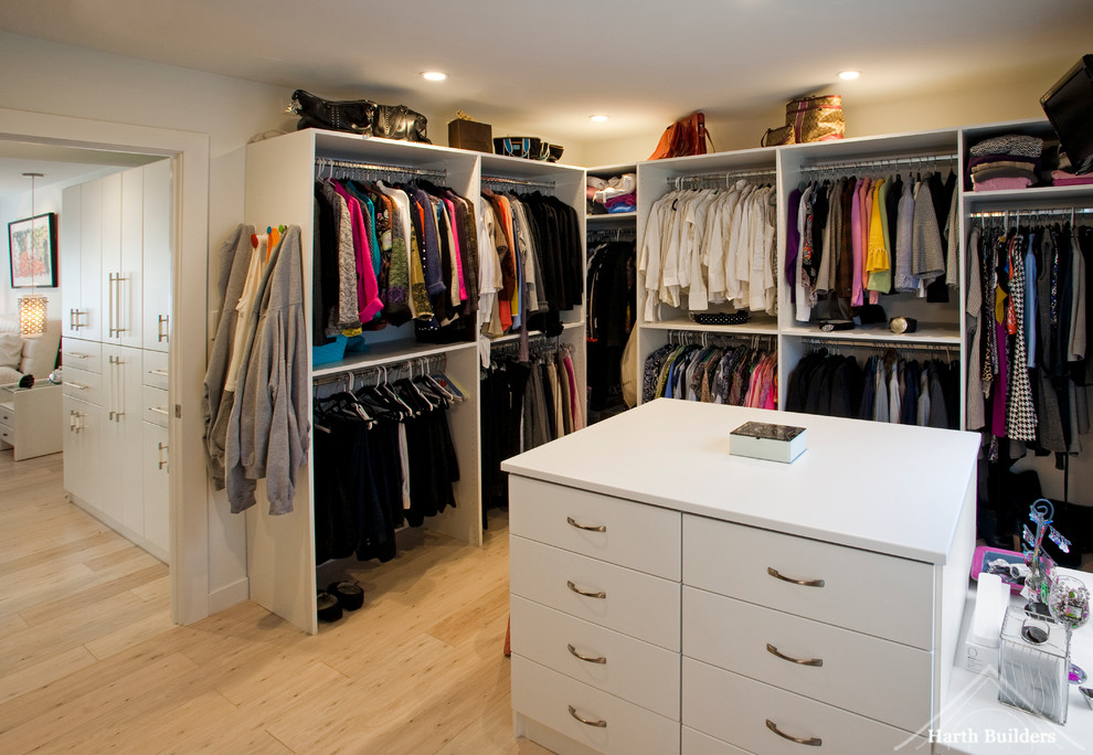 Idéer för mellanstora eklektiska walk-in-closets för kvinnor, med släta luckor, vita skåp och ljust trägolv