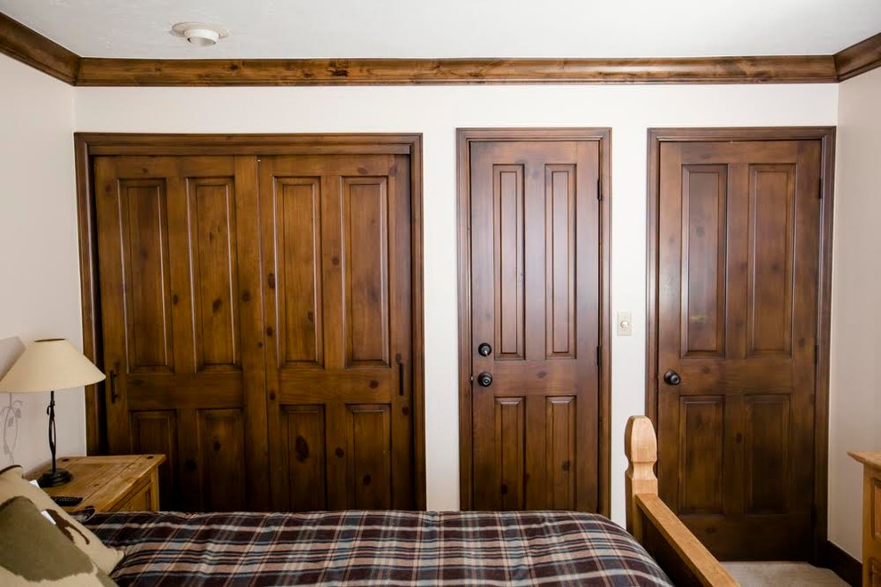 Imagen de armario unisex rural de tamaño medio con puertas de armario de madera en tonos medios y moqueta