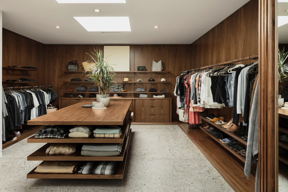 Idées déco pour un grand dressing room sud-ouest américain en bois foncé avec sol en béton ciré et un sol gris.