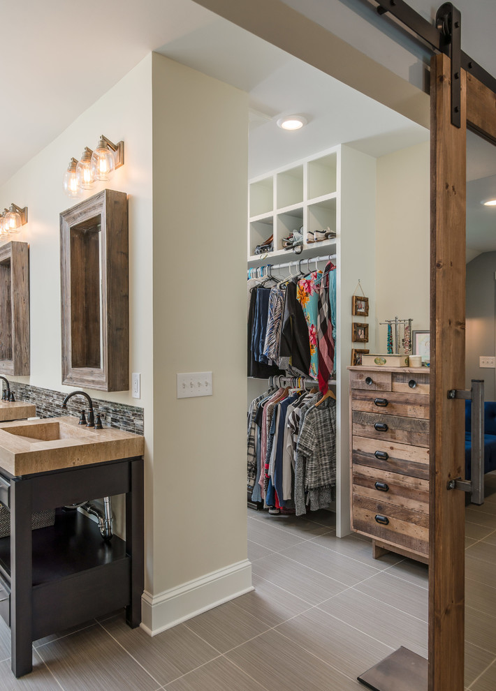 Inspiration for a gender neutral walk-in wardrobe in Nashville with flat-panel cabinets, white cabinets and porcelain flooring.