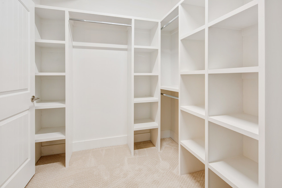 Modelo de armario vestidor unisex de estilo de casa de campo de tamaño medio con puertas de armario blancas, moqueta y suelo beige