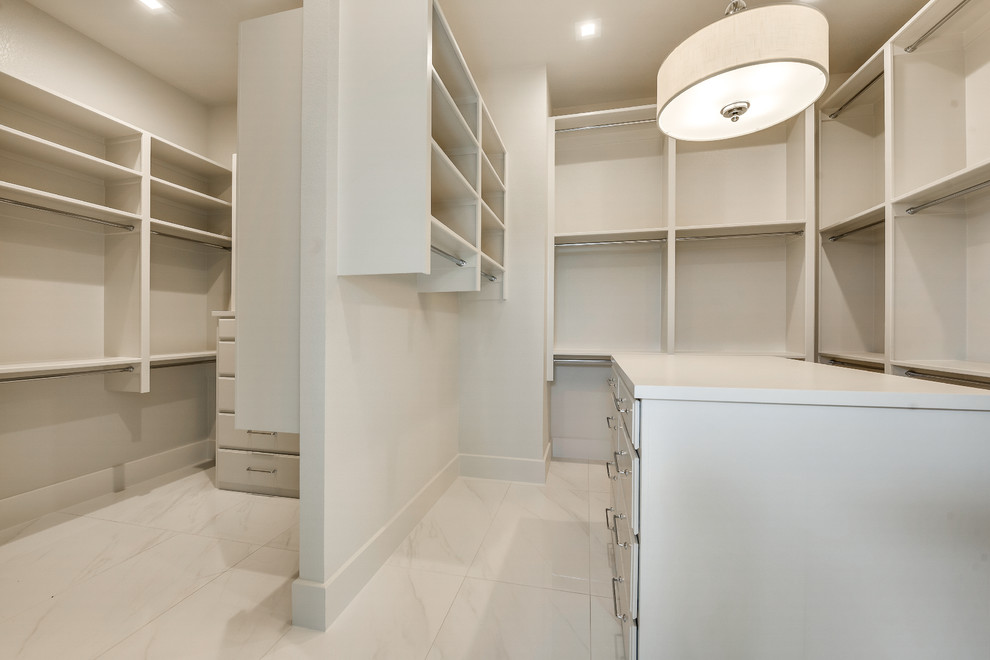 Immagine di una grande cabina armadio unisex minimalista con ante a persiana, ante bianche, pavimento in marmo e pavimento bianco