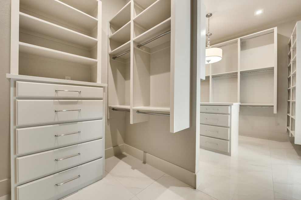 Diseño de armario vestidor unisex minimalista grande con armarios con puertas mallorquinas, puertas de armario blancas, suelo de mármol y suelo blanco