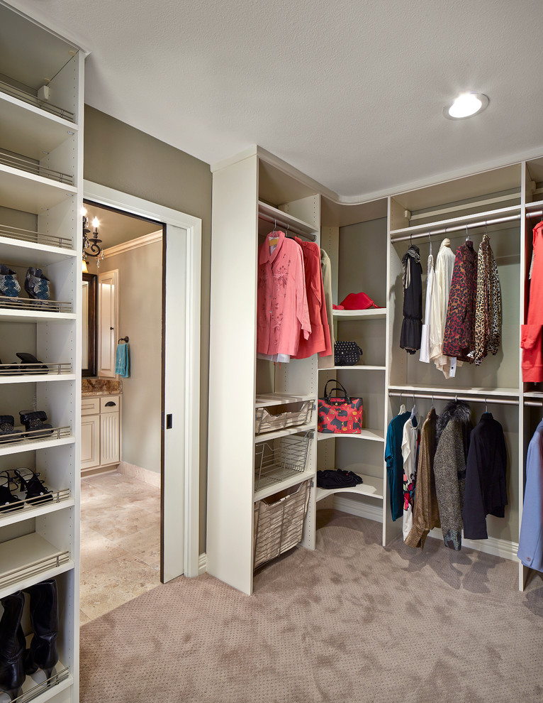 На фото: гардеробная комната унисекс в стиле неоклассика (современная классика) с белыми фасадами и ковровым покрытием