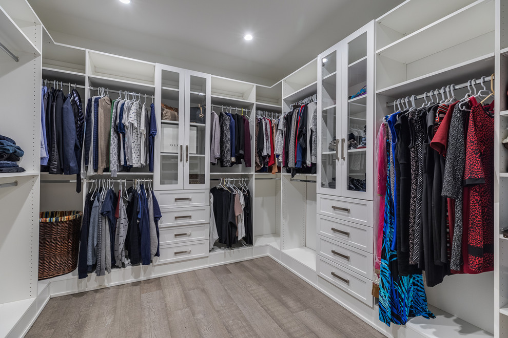 Diseño de armario vestidor unisex actual de tamaño medio con armarios estilo shaker, puertas de armario marrones, suelo de madera clara y suelo gris