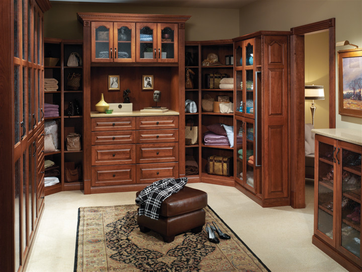 Ejemplo de armario vestidor de hombre clásico grande con armarios con paneles con relieve, puertas de armario de madera oscura, moqueta y suelo beige