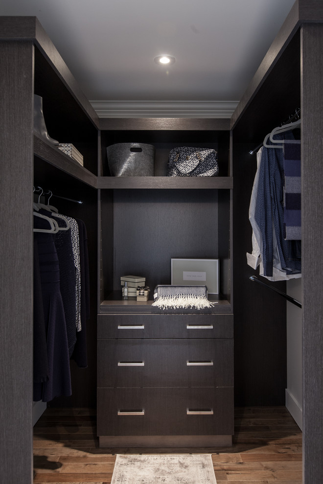 Immagine di una piccola cabina armadio unisex minimalista con ante lisce, ante marroni, pavimento in legno massello medio e pavimento marrone