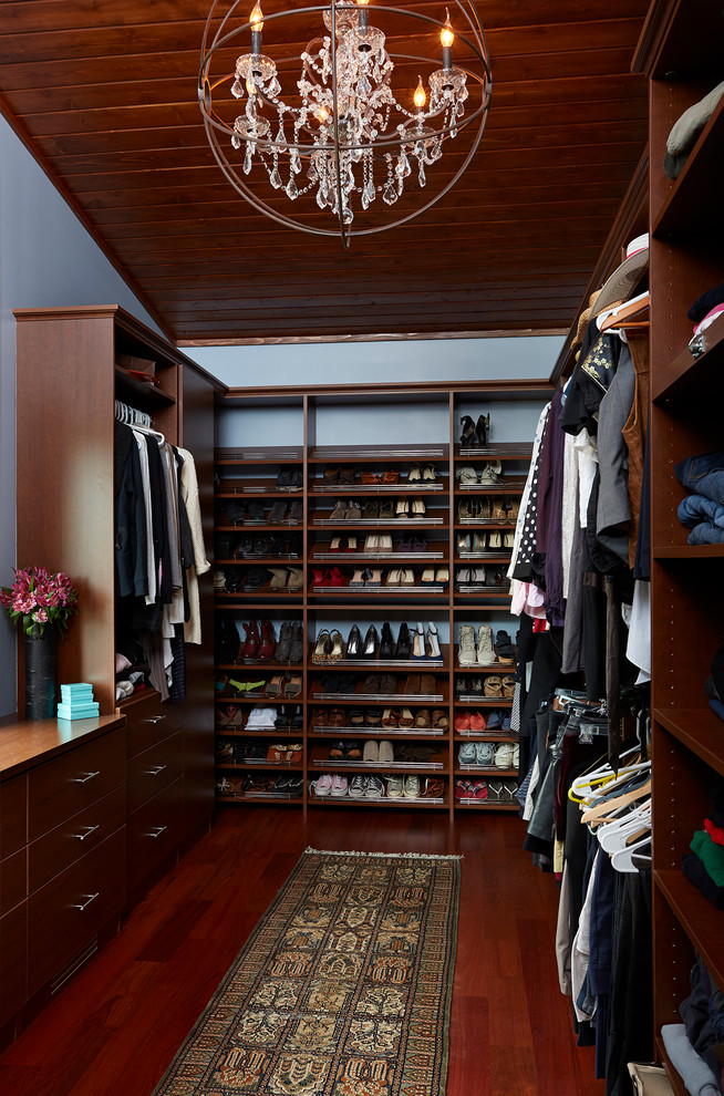 Photo of a large classic walk-in wardrobe for women in Minneapolis with shaker cabinets, brown cabinets and dark hardwood flooring.