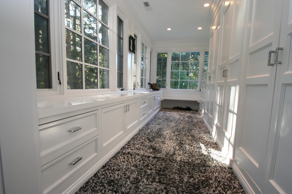 Example of a transitional gender-neutral carpeted walk-in closet design in Chicago with recessed-panel cabinets and white cabinets