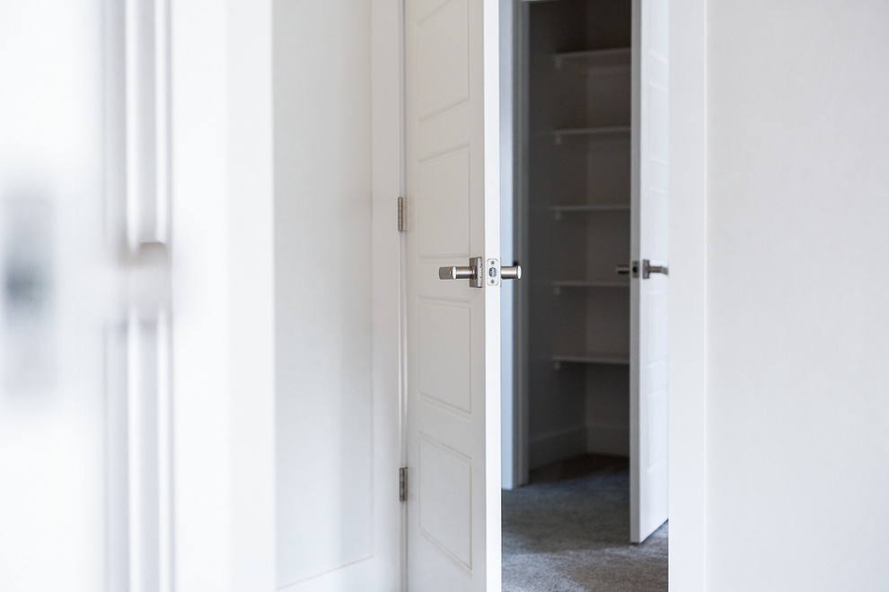 Ejemplo de armario unisex tradicional renovado de tamaño medio con armarios abiertos, puertas de armario blancas, moqueta y suelo gris