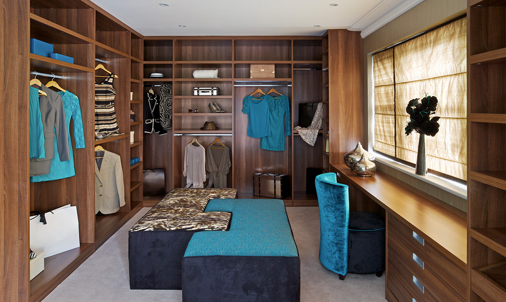 Photo of a large modern gender neutral walk-in wardrobe in New York with flat-panel cabinets, medium wood cabinets, carpet and beige floors.