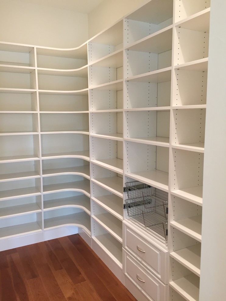 Design ideas for a medium sized traditional gender neutral walk-in wardrobe in Miami with raised-panel cabinets, white cabinets and medium hardwood flooring.