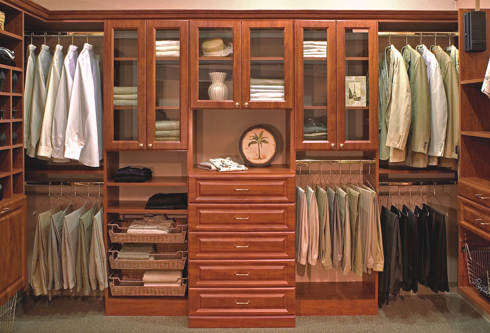 Diseño de armario vestidor de hombre clásico grande con armarios con paneles con relieve, puertas de armario de madera oscura y moqueta