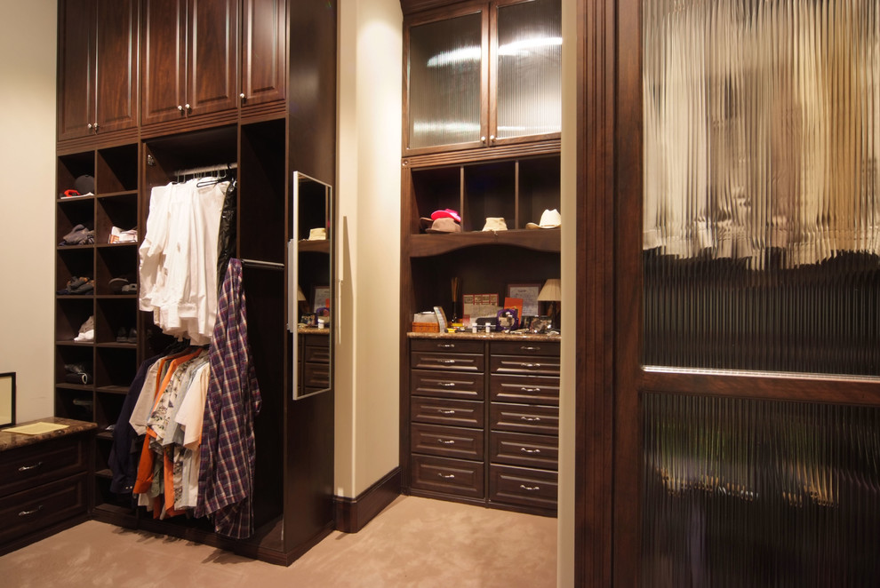 Imagen de armario vestidor unisex clásico grande con armarios con paneles con relieve, puertas de armario de madera en tonos medios, moqueta y suelo beige