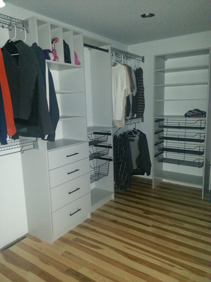 Ejemplo de vestidor unisex minimalista de tamaño medio con armarios con paneles lisos, puertas de armario blancas y suelo de madera oscura
