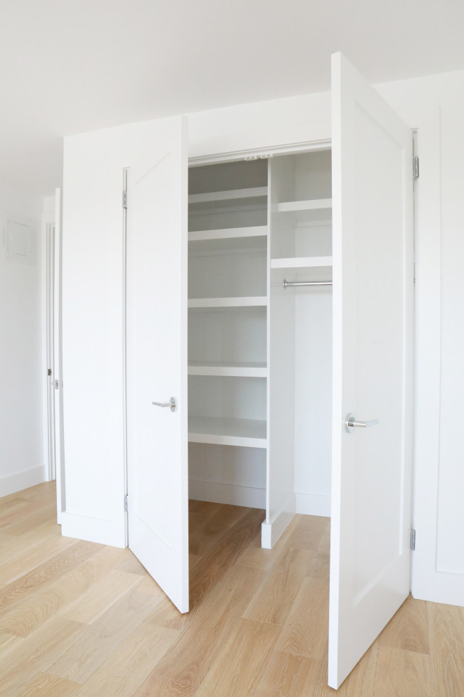 Ejemplo de armario y vestidor unisex minimalista pequeño con a medida, suelo de bambú y suelo marrón