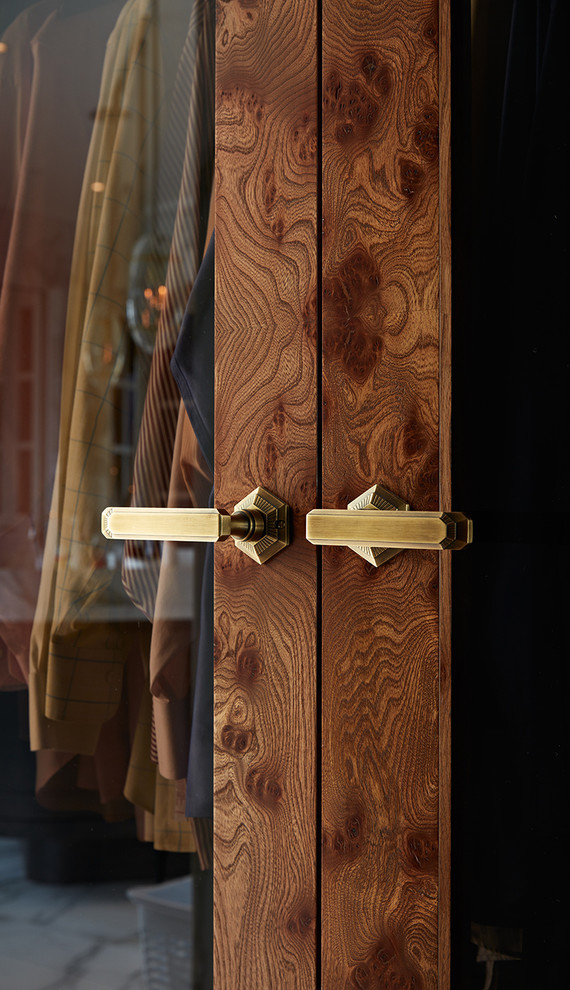 サンフランシスコにあるトランジショナルスタイルのおしゃれなウォークインクローゼット (ガラス扉のキャビネット、中間色木目調キャビネット) の写真