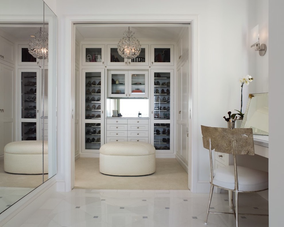 Стильный дизайн: большая гардеробная комната унисекс в стиле неоклассика (современная классика) с стеклянными фасадами, белыми фасадами и ковровым покрытием - последний тренд
