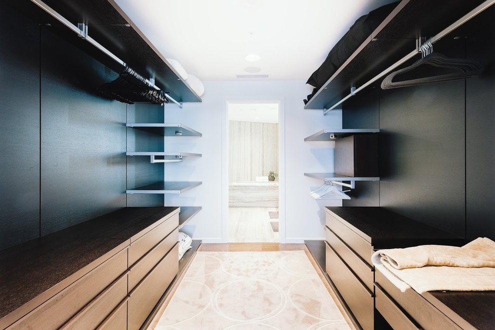 Design ideas for a large modern gender neutral walk-in wardrobe in Vancouver with flat-panel cabinets, dark wood cabinets, plywood flooring and brown floors.
