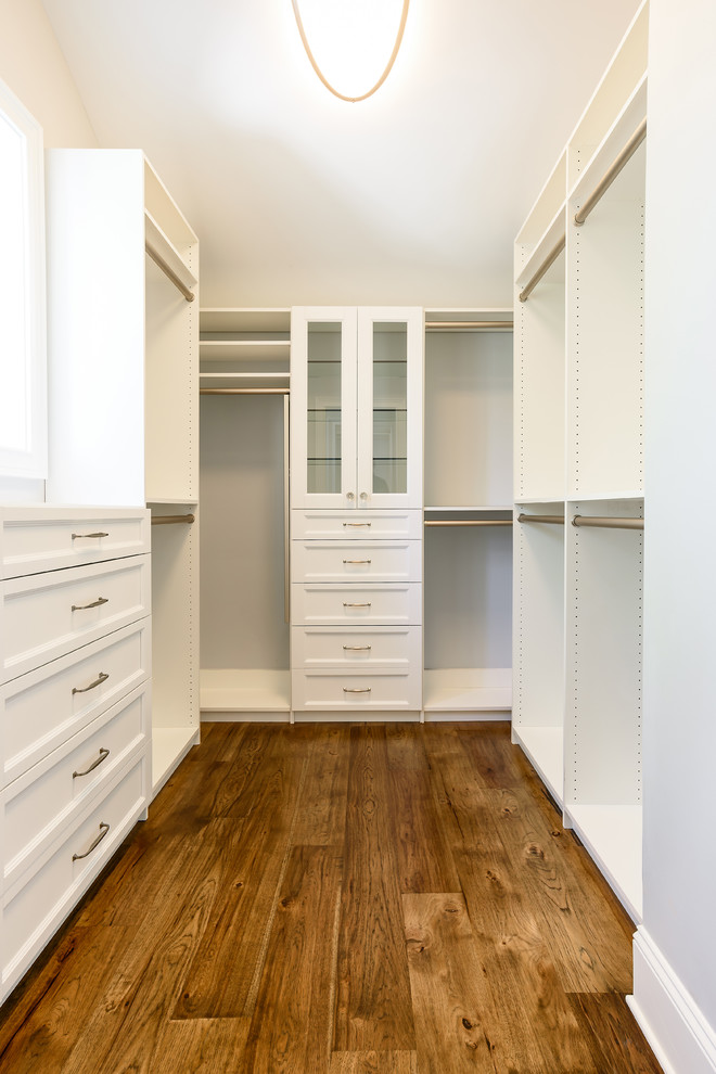 Medium sized coastal gender neutral walk-in wardrobe in Jacksonville with shaker cabinets, white cabinets and medium hardwood flooring.