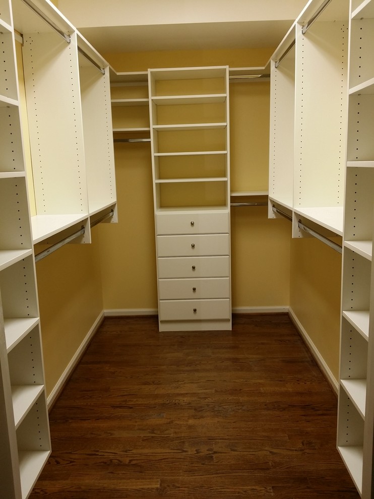 Inspiration for a medium sized classic walk-in wardrobe for women in Other with flat-panel cabinets, white cabinets and dark hardwood flooring.