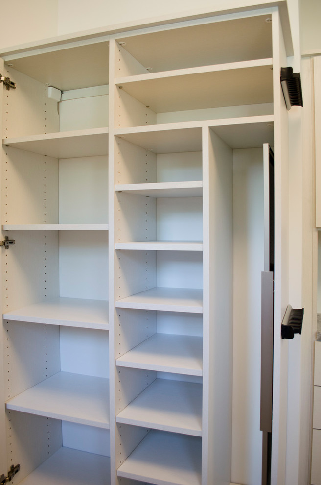 Foto de armario vestidor unisex moderno grande con armarios abiertos, puertas de armario blancas, moqueta y suelo marrón