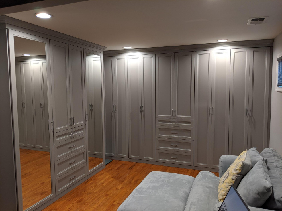 Large elegant gender-neutral medium tone wood floor walk-in closet photo in New York with beaded inset cabinets and gray cabinets