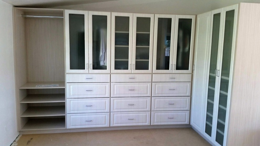 Ejemplo de armario vestidor unisex tradicional de tamaño medio con puertas de armario blancas, armarios abiertos y suelo de madera oscura