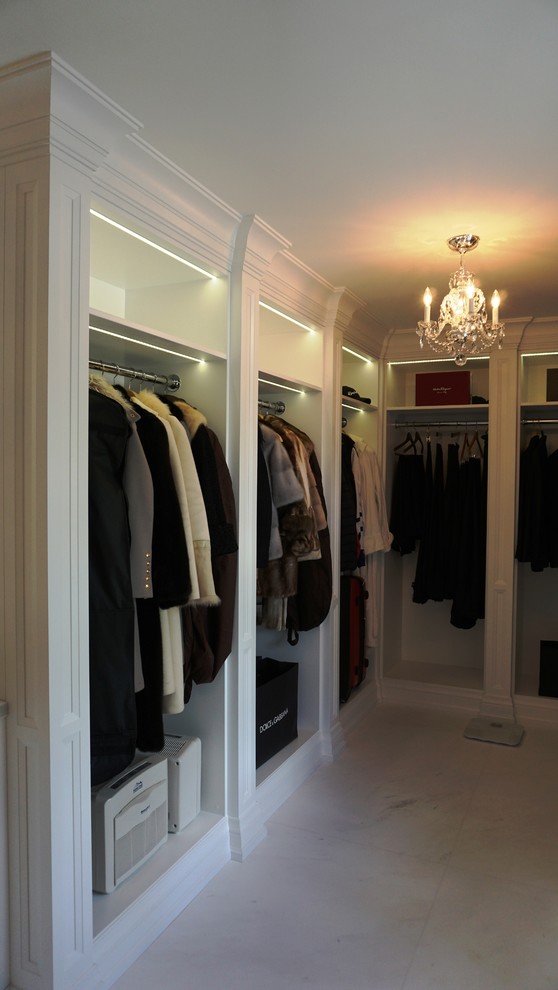 Imagen de vestidor clásico renovado extra grande con puertas de armario blancas y suelo de mármol