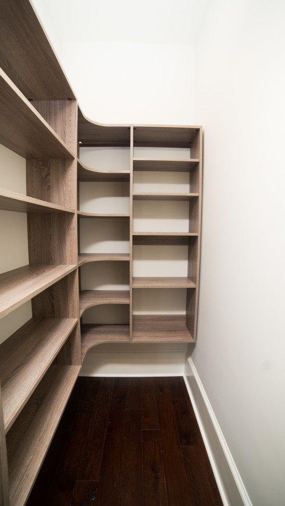 Photo of a medium sized traditional gender neutral walk-in wardrobe in Other with medium hardwood flooring and brown floors.