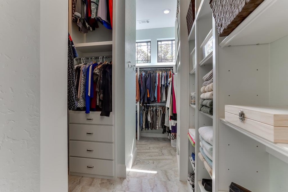 Photo of a large traditional gender neutral dressing room in Houston with flat-panel cabinets, white cabinets, travertine flooring and beige floors.