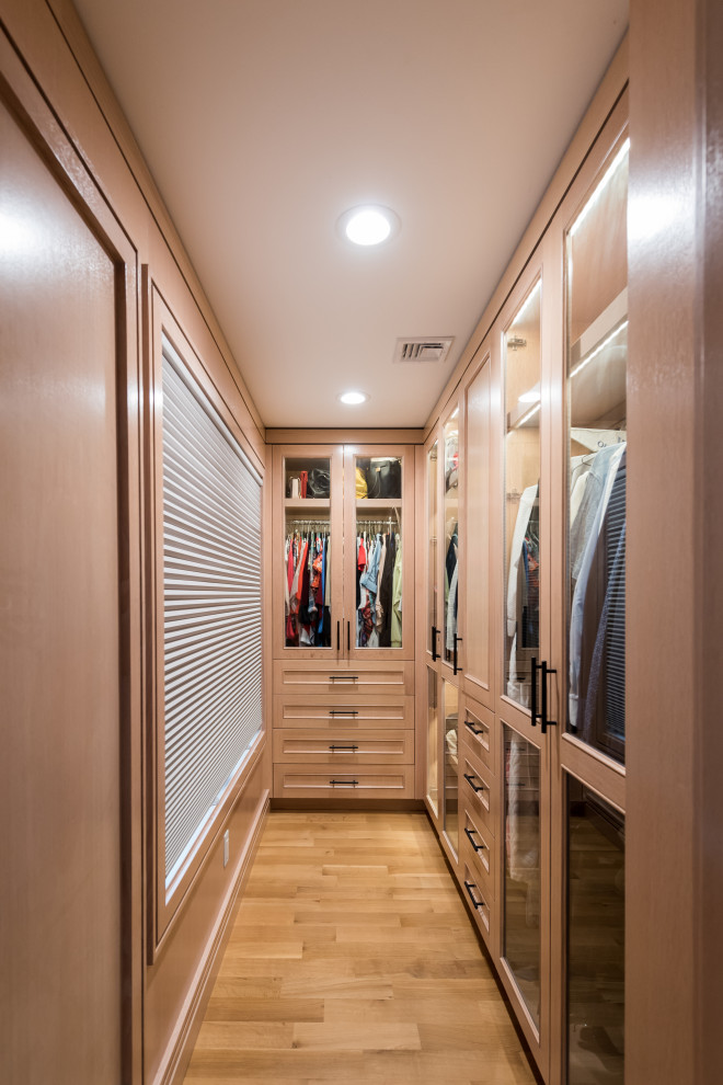 Bild på ett litet funkis walk-in-closet för könsneutrala, med luckor med glaspanel, skåp i ljust trä, ljust trägolv och brunt golv