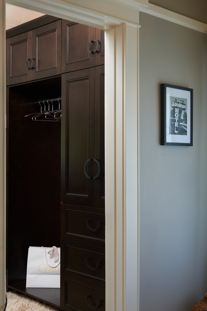 Diseño de armario vestidor unisex retro pequeño con puertas de armario de madera en tonos medios y moqueta