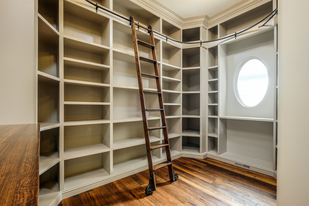 Diseño de armario vestidor unisex clásico renovado grande con armarios abiertos, puertas de armario beige y suelo de madera en tonos medios