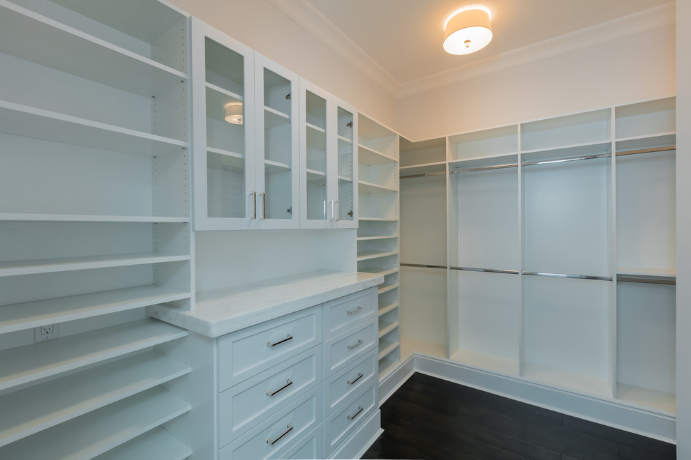 Foto de armario vestidor unisex clásico grande con armarios estilo shaker, puertas de armario blancas y suelo de madera oscura