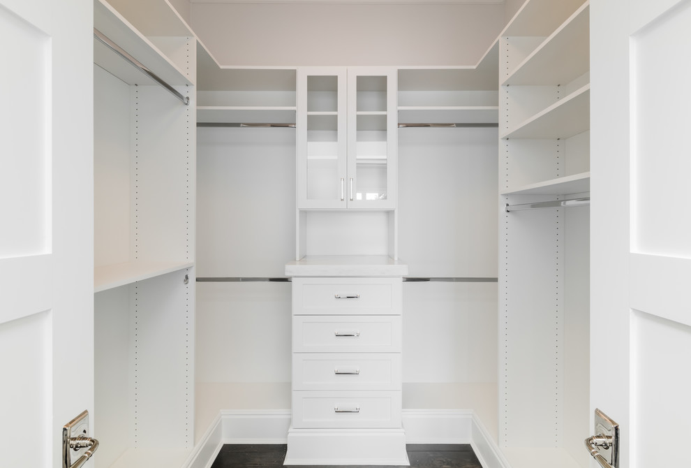 Imagen de armario vestidor unisex tradicional de tamaño medio con armarios estilo shaker, puertas de armario blancas y suelo de madera oscura