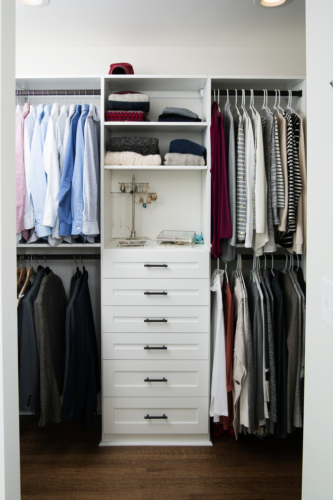 Imagen de armario vestidor unisex tradicional de tamaño medio con armarios estilo shaker, puertas de armario blancas, suelo de madera en tonos medios y suelo marrón