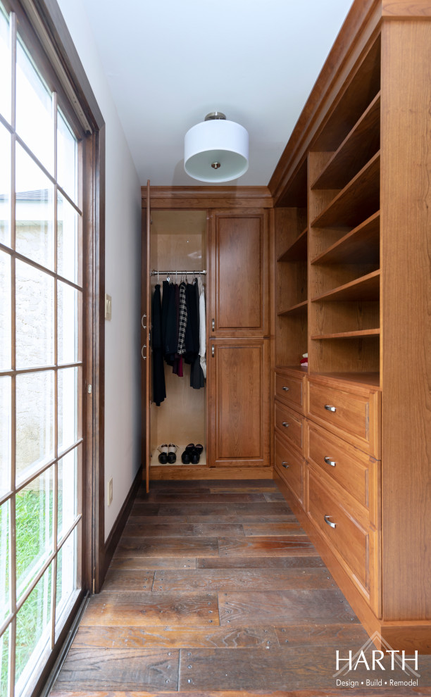 Photo of a small walk-in wardrobe for women in Philadelphia with raised-panel cabinets, medium wood cabinets, medium hardwood flooring and brown floors.