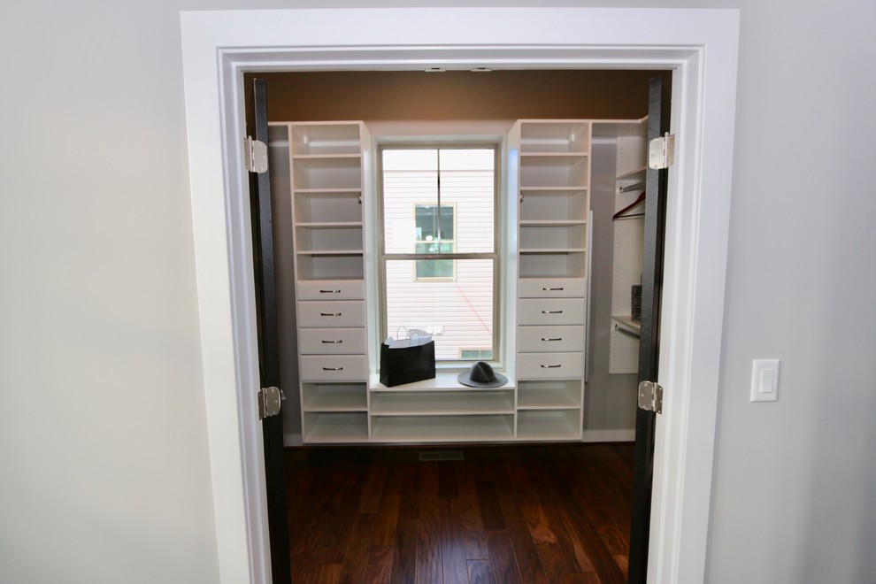 Modelo de armario vestidor unisex minimalista de tamaño medio con armarios abiertos y suelo de madera oscura