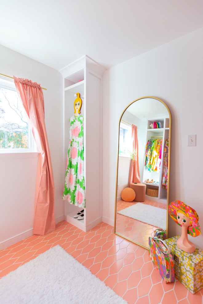 Aménagement d'un grand dressing rétro pour une femme avec des portes de placard blanches, un sol en carrelage de céramique et un sol rose.