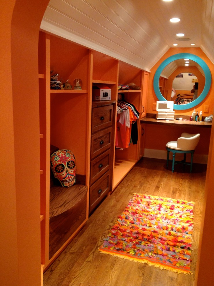 Cette image montre un dressing room bohème en bois brun de taille moyenne et neutre avec un placard à porte shaker.
