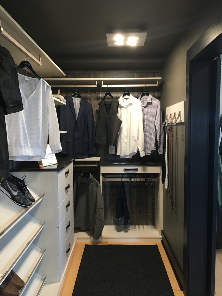 Ejemplo de armario vestidor minimalista de tamaño medio con armarios con paneles lisos, puertas de armario de madera clara y suelo de madera clara
