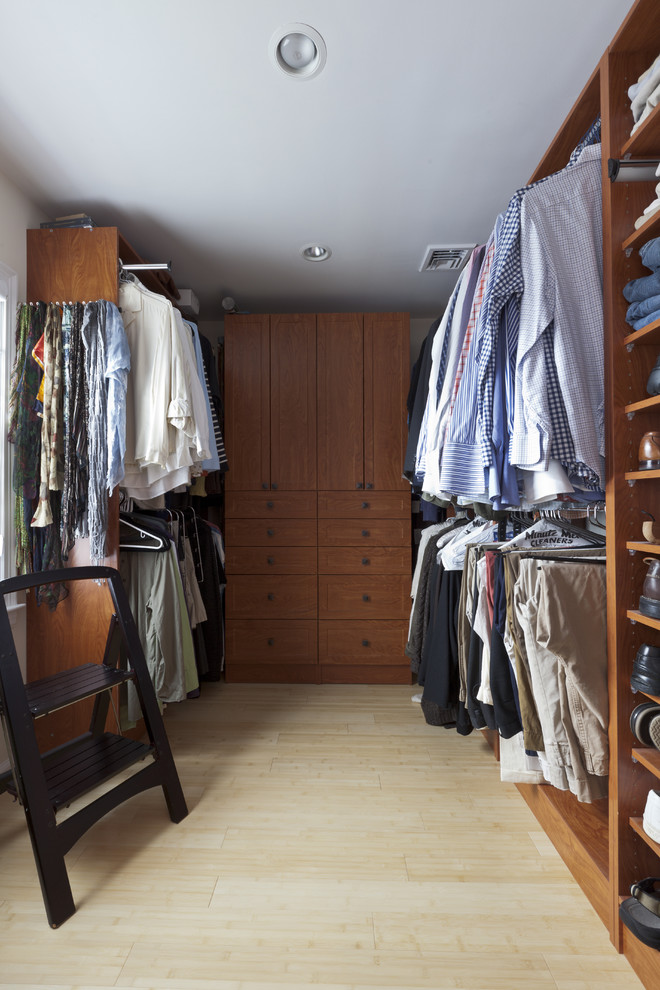 Foto de armario vestidor unisex bohemio de tamaño medio con armarios con paneles empotrados, puertas de armario de madera oscura y suelo de madera clara